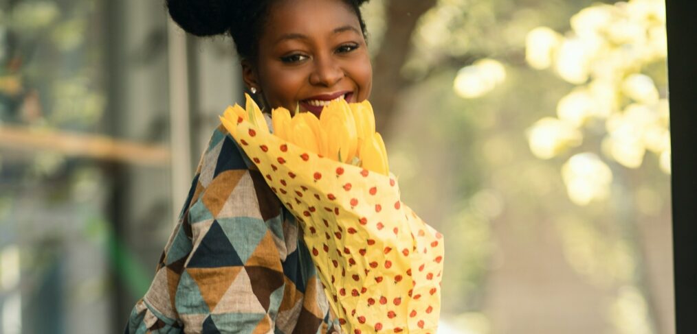 black girl holding flowers and smiling