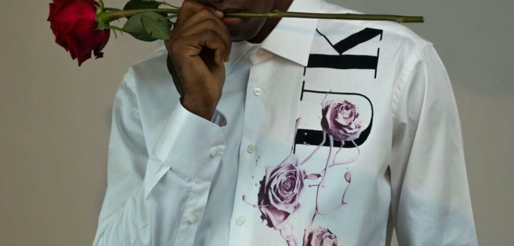 BLACK BOY WEARING A WHITE SHIRT AND HOLDINFG A ROSE IN HIS MOUTH