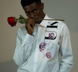 BLACK BOY WEARING A WHITE SHIRT AND HOLDINFG A ROSE IN HIS MOUTH