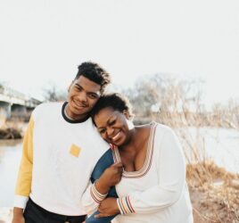 black son with mother standing outside happily