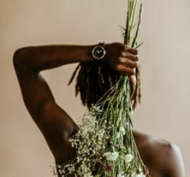 BLACK MAN HOLDING FLOWERS BEHINDE